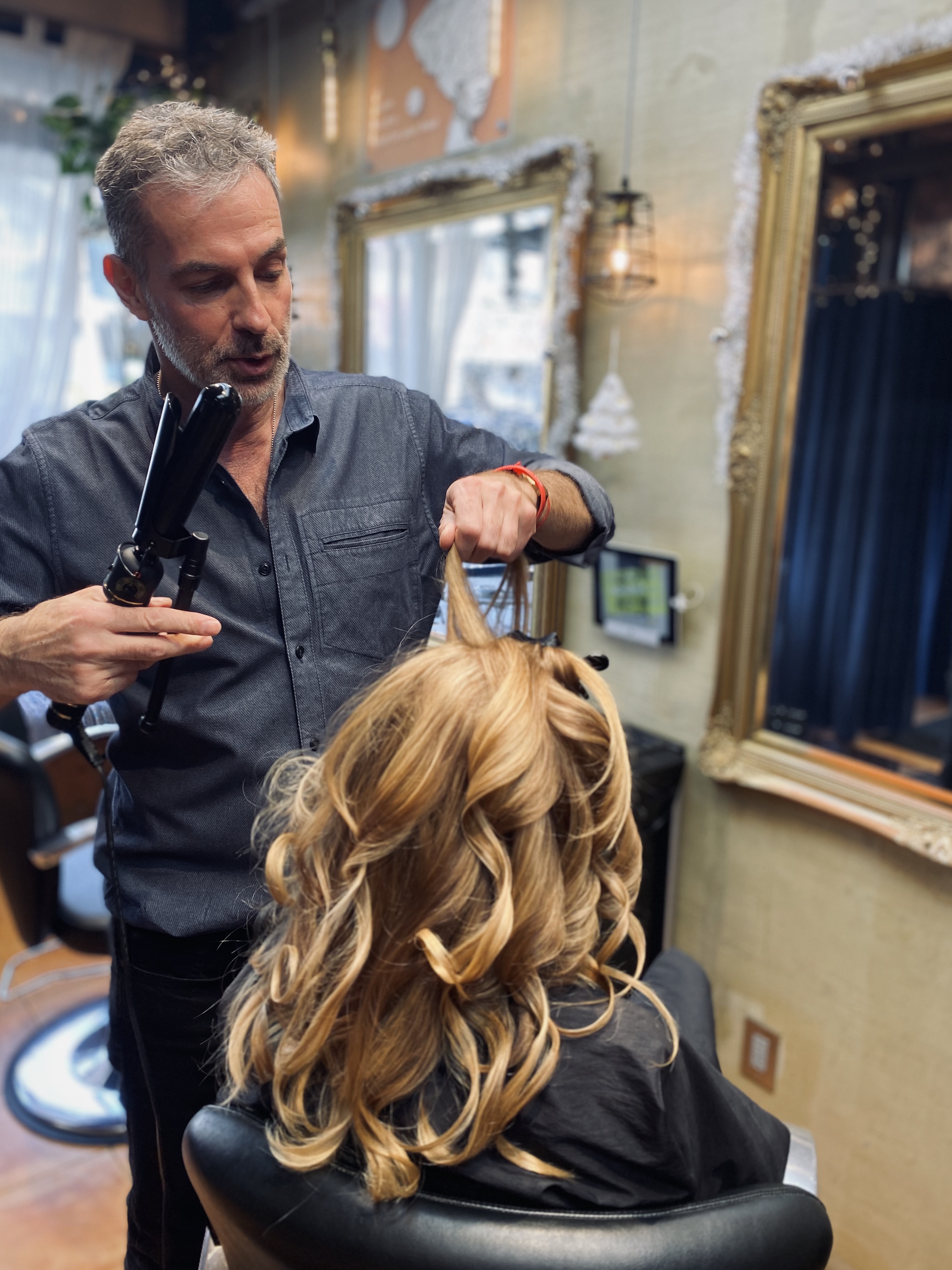 Curling honey blonde at the gilded mirror